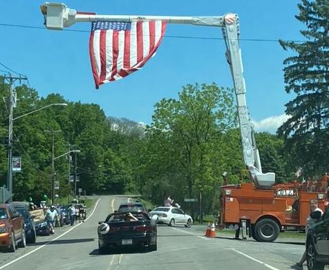 A crane holds an American Flag over the parade route for the graduates’ parade in Newfield in 2020. This year’s parade is coming up later this month.